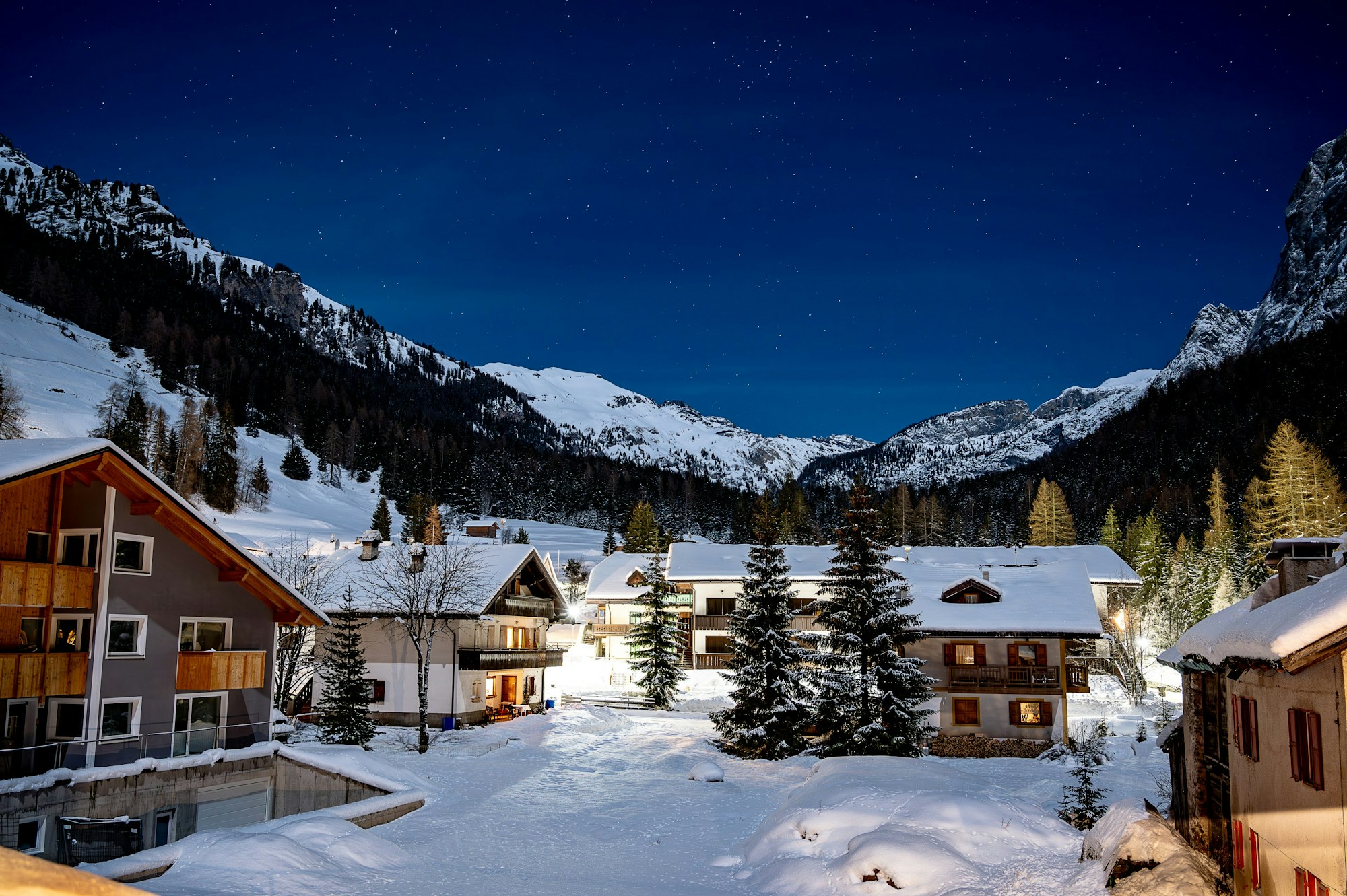 Station de ski de montagne éclairée la nuit, dans les Dolomites