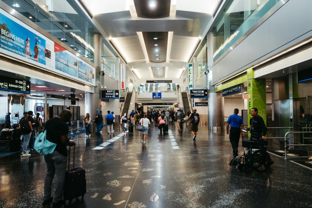 Voyageurs dans un grand hall d'aéroport, bagages à la main