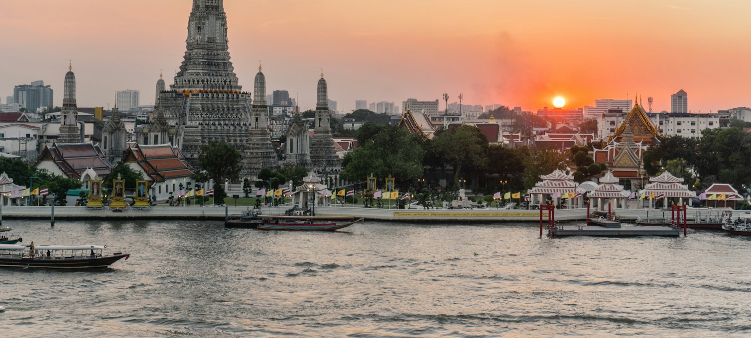 Boot auf dem Chao Phraya bei Einbruch der Dämmerung in Bangkok