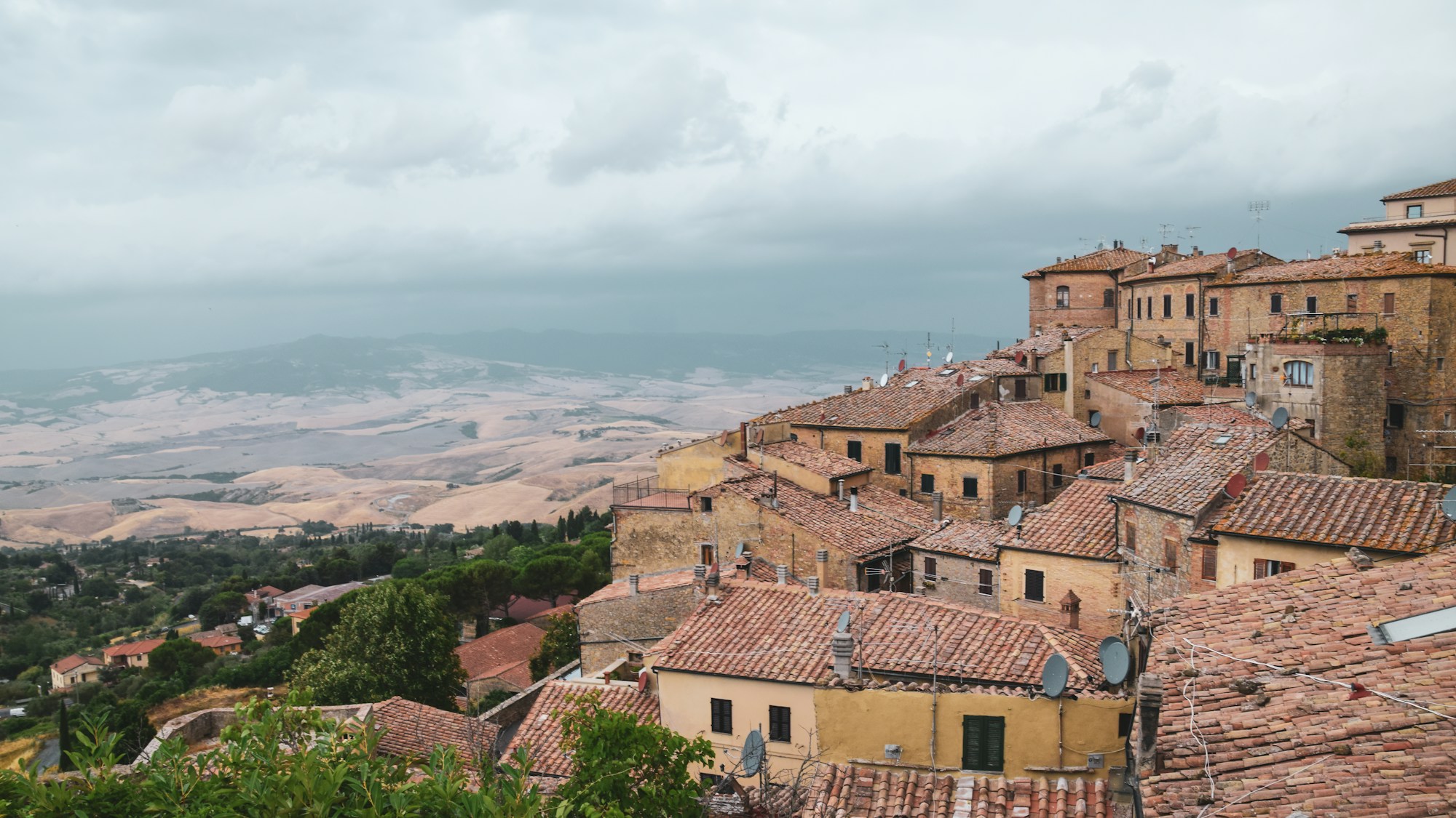 Terracotta rooftops of a medieval Tuscan village on a hill