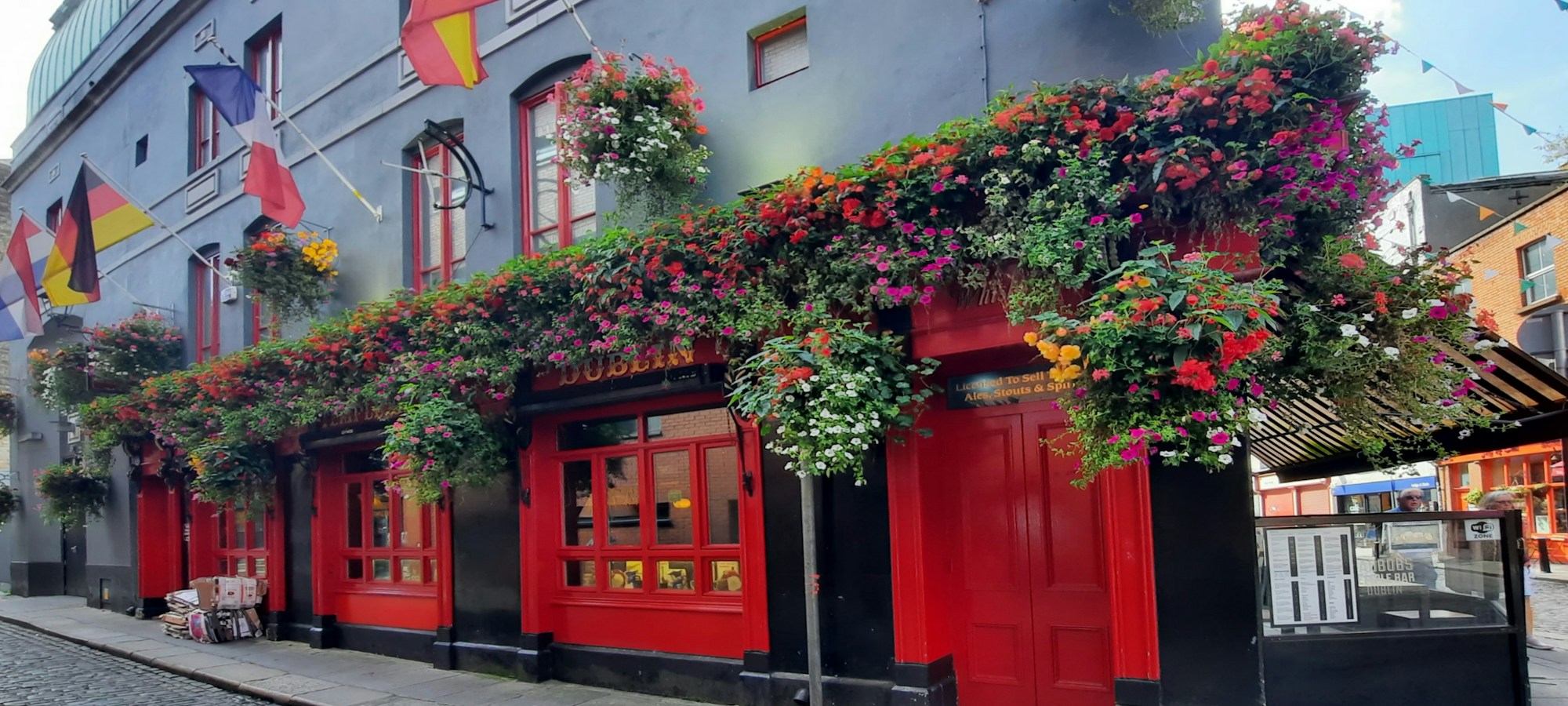 Fassade eines rot geschmückten Pubs in Temple Bar, Dublin, bei Tageslicht