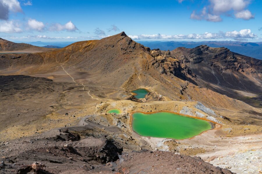 Sentier de cendres volcaniques du Tongariro Alpine Crossing sous un ciel bleu, en Nouvelle-Zélande