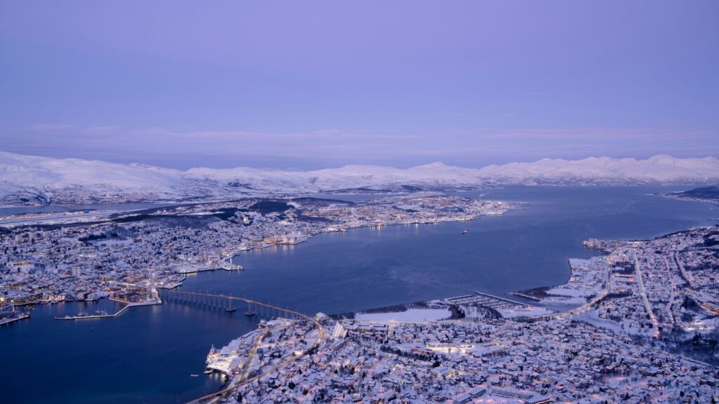 Vue panoramique de Tromsø en hiver, avec le pont et les montagnes enneigées
