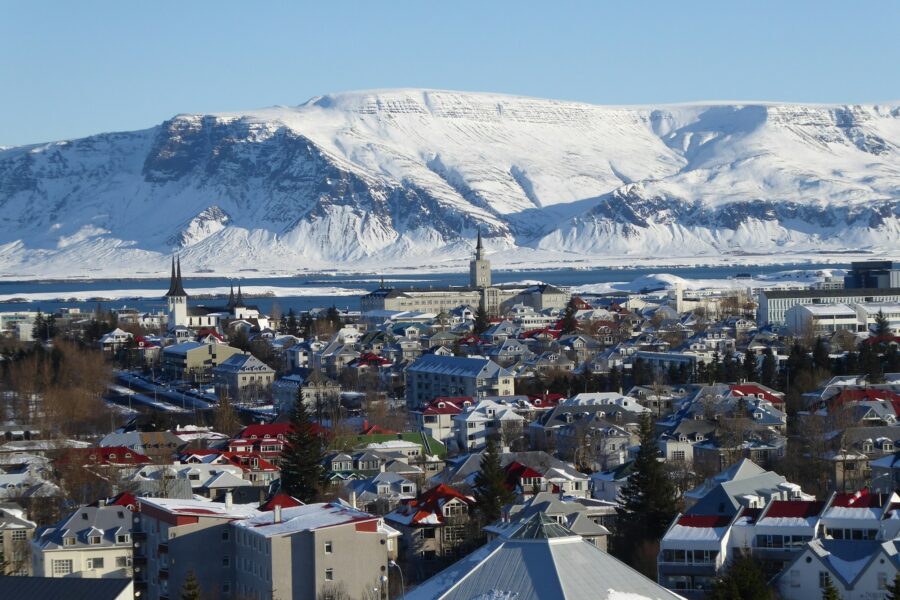 Toits colorés de Reykjavik sous la neige, avec une montagne enneigée en arrière-plan