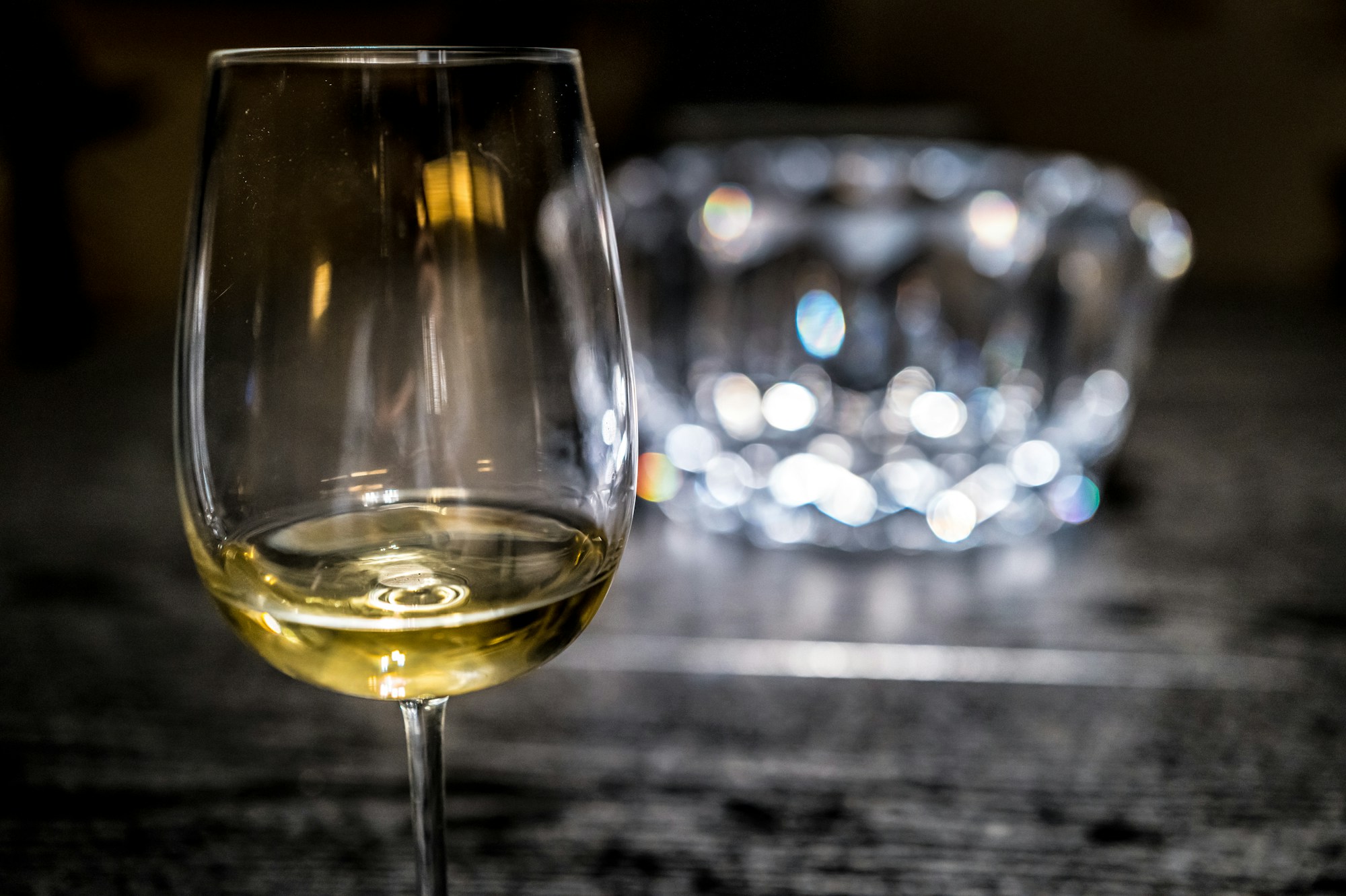 Glas Weißwein auf einem Holz-Verkostungstisch