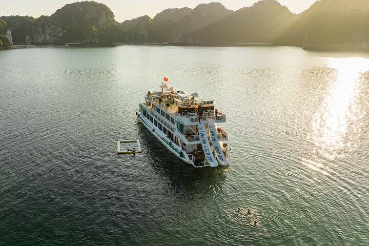 Bateau en bois amarré parmi les îles de calcaire de la baie de Lan Ha