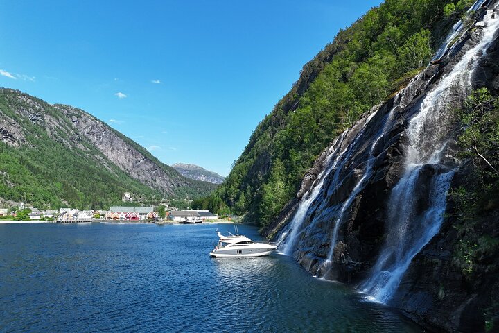 Private boat on a fjord, waterfalls in the background