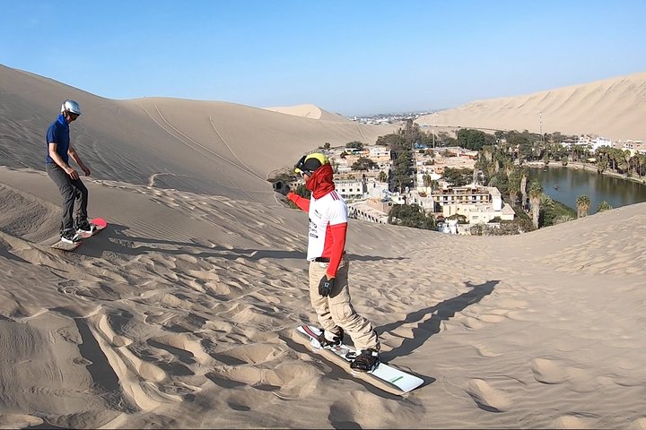 Sandboarder riding a dune near Ica, Peru
