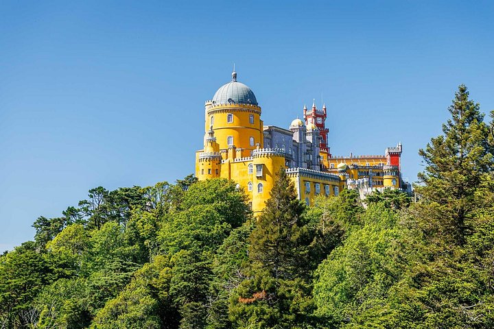 Pena Palace in Sintra, its yellow and red towers rising above the green forest