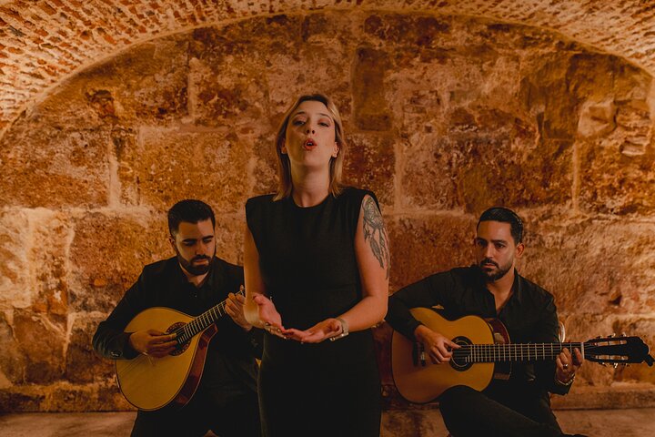 Guitarist and singer performing fado in a small Lisbon room