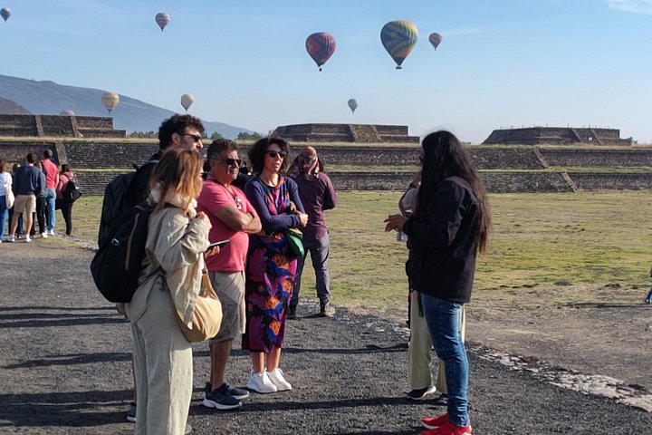 Petit groupe marchant sur le site de Teotihuacan au début d'une visite matinale