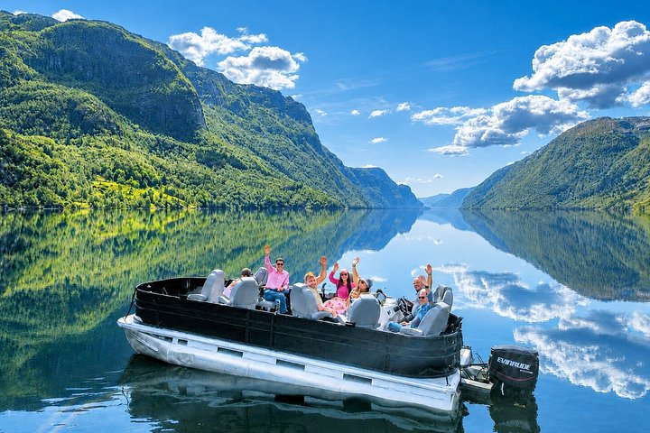 Passenger pontoon boat on a fjord, mountains in the background