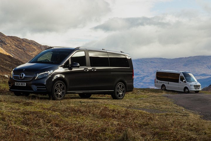 Voiture avec chauffeur privé garée près d'un lac des Highlands