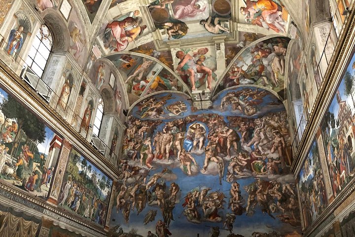 Visiteurs qui lèvent les yeux vers le plafond de la chapelle Sixtine pendant une visite en petit groupe