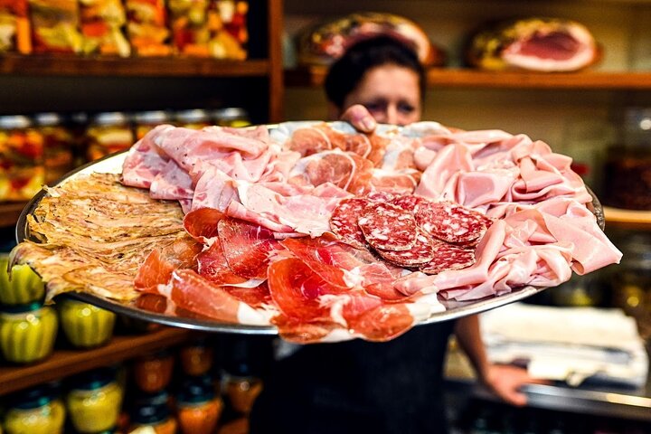 Visitors walking past market stalls in Bologna