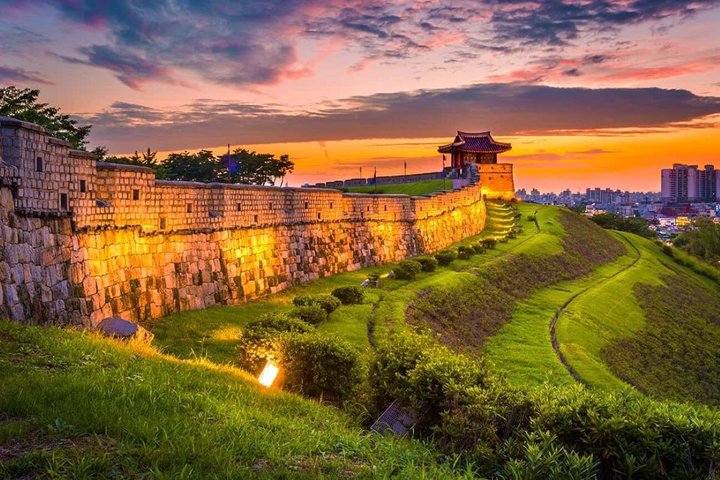 Stone fortress wall on a hill above a Korean city