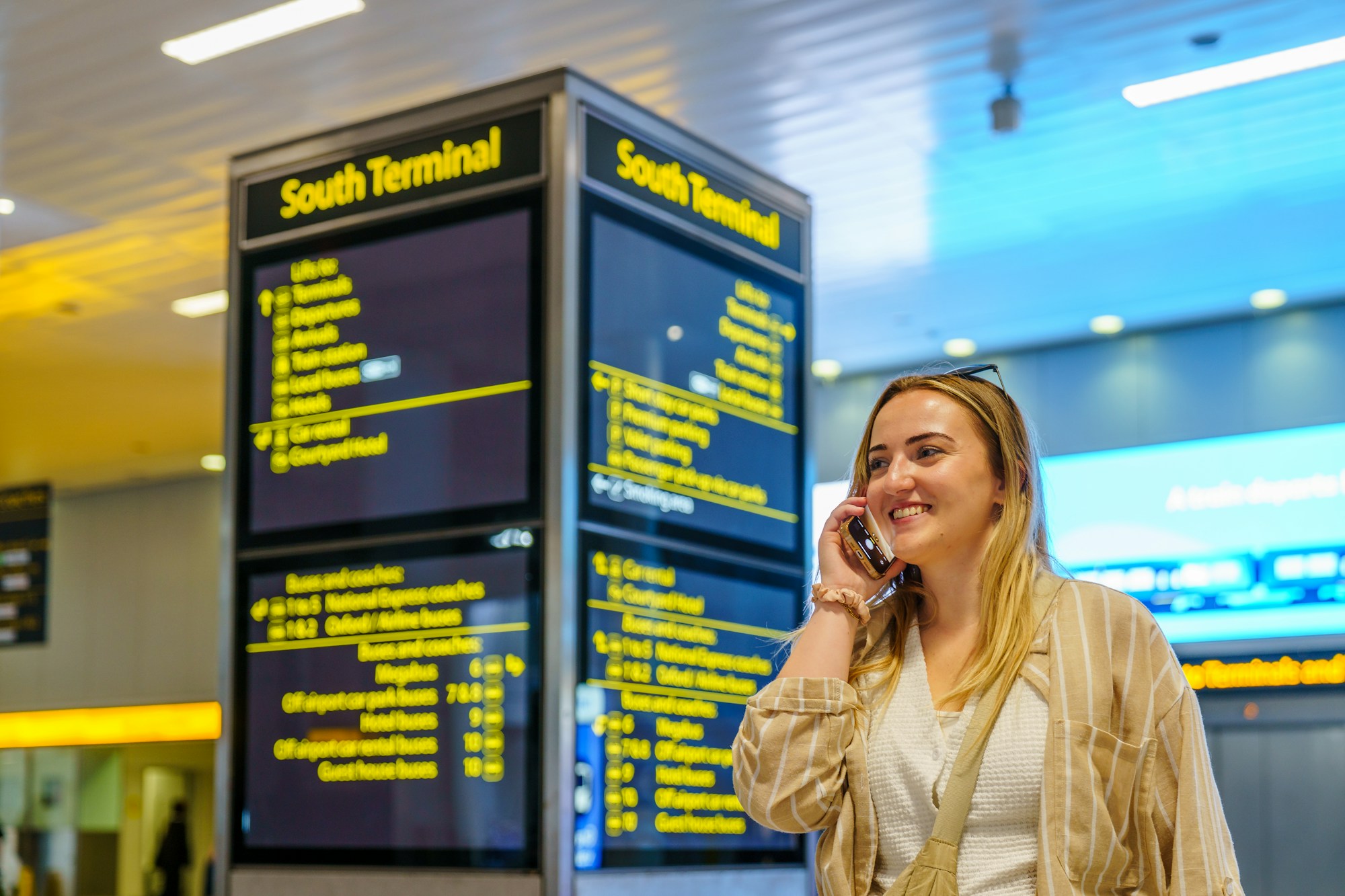 Traveller checking her phone in an airport terminal