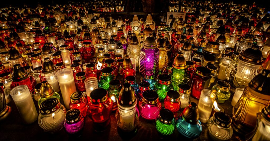 Bougies funéraires allumées dans un cimetière polonais à la tombée de la nuit