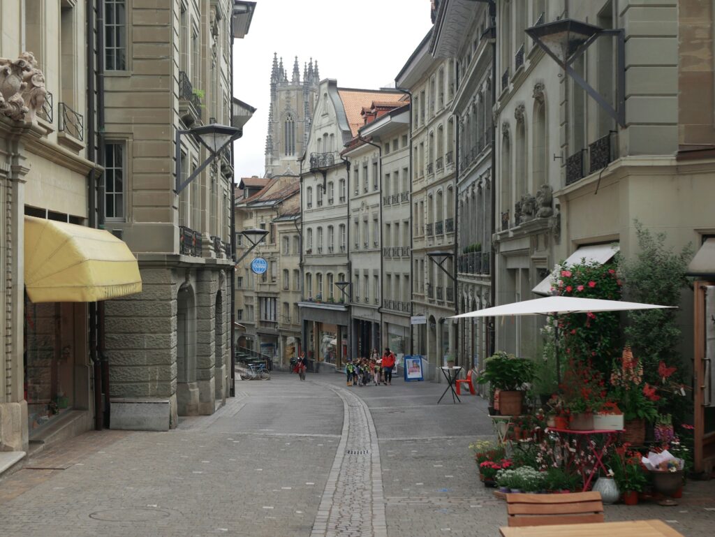 Rue pavée de la vieille ville de Berne, façades historiques et clocher de la cathédrale au loin