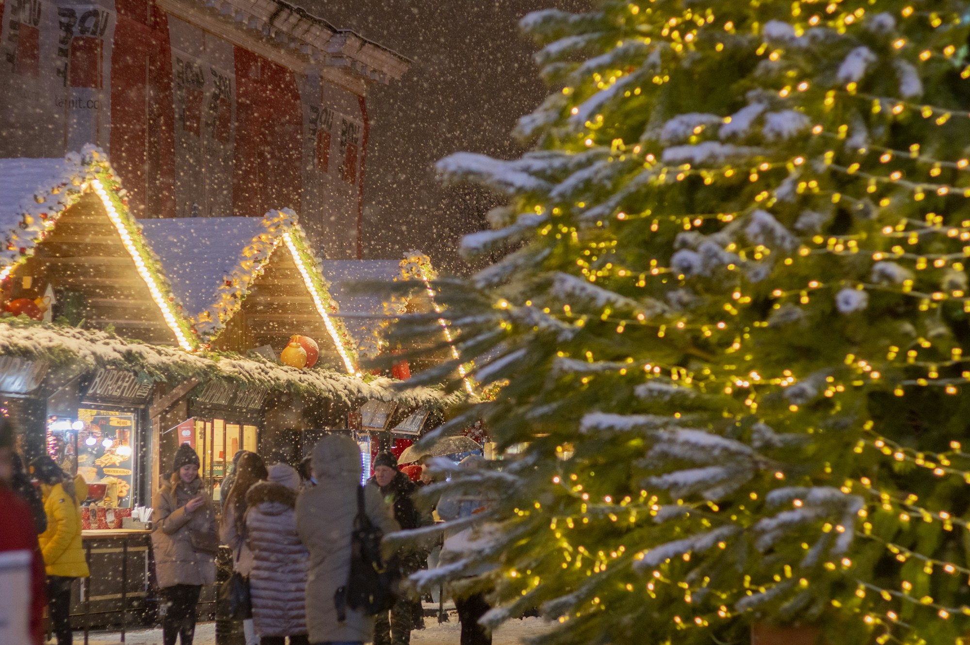 Chalets éclairés d'un marché de Noël en fin de journée