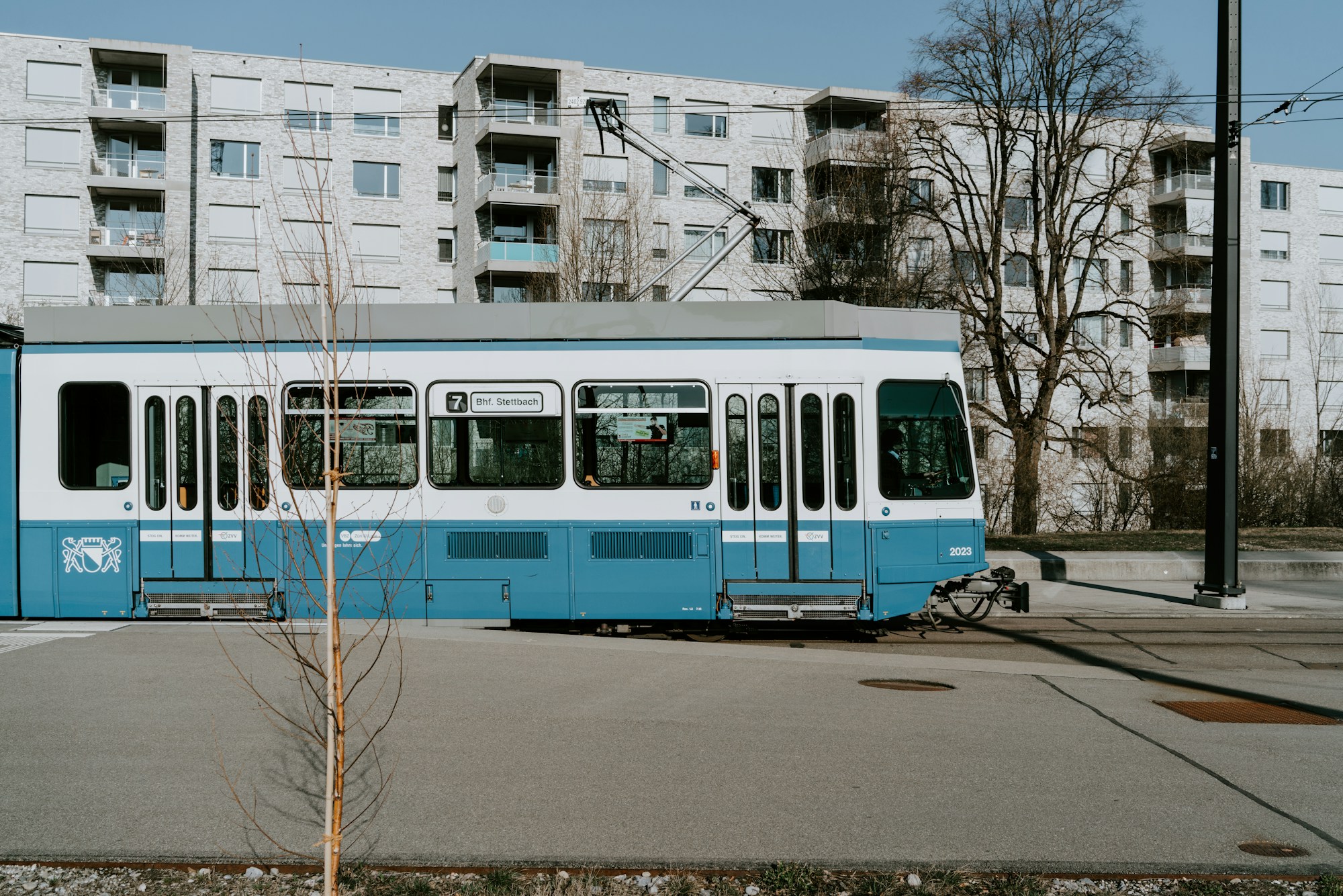 Tram bleu et blanc de Zurich, ligne 7, à un arrêt par temps clair