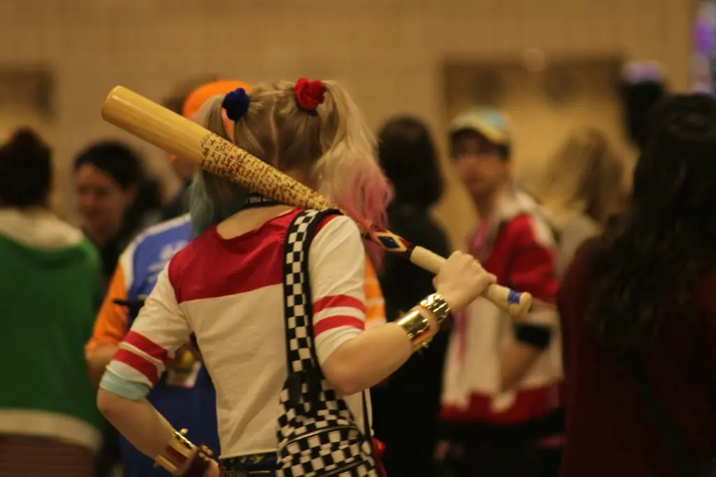 Cosplayeuse en costume de super-heroine saluant la foule lors d'une convention de pop culture
