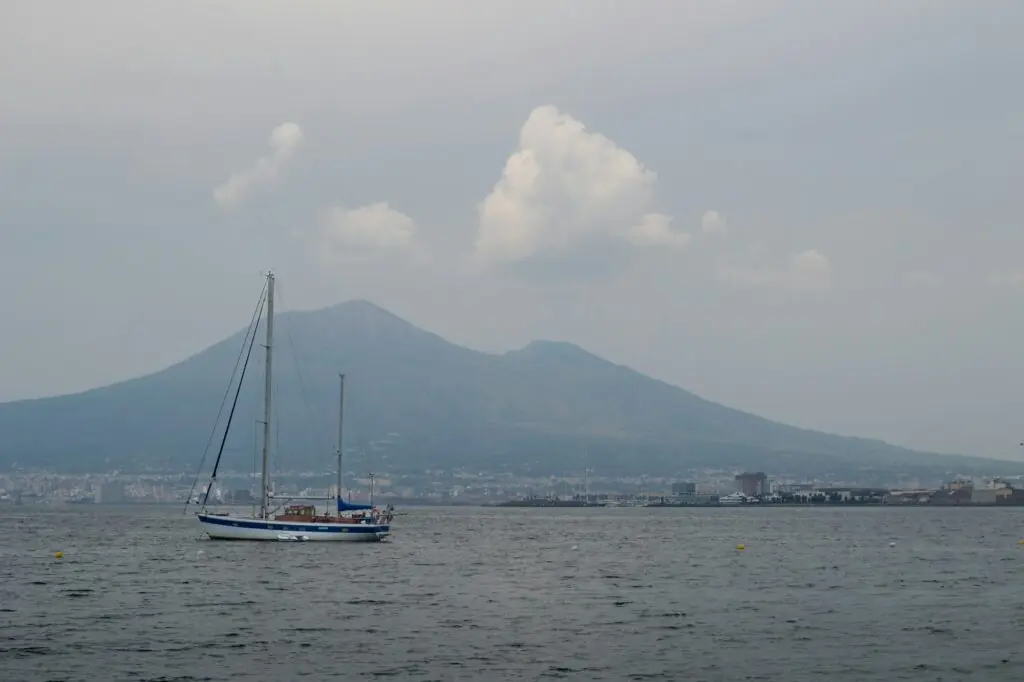 Voiliers dans le golfe de Naples au coucher du soleil, avec le Vesuve en arriere-plan