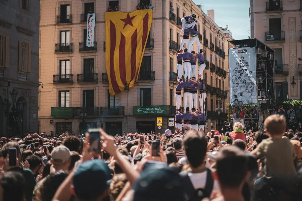 Castellers construisant une tour humaine devant une foule pendant un festival en Catalogne