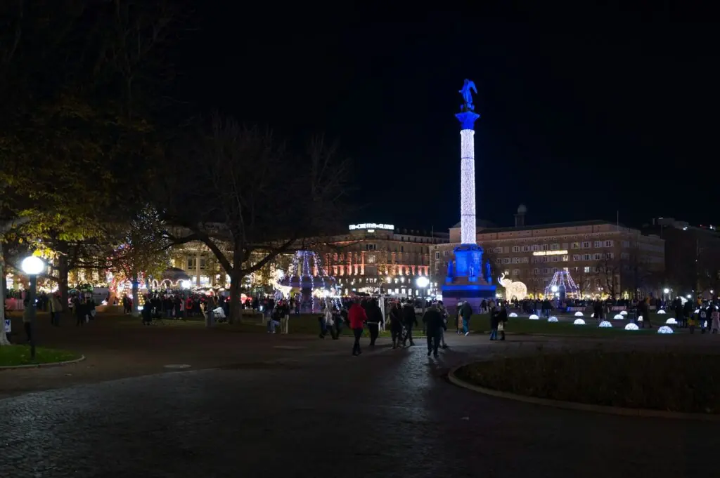 Vue nocturne de la place Schlossplatz à Stuttgart pendant le marché de Noël, avec une colonne illuminée
