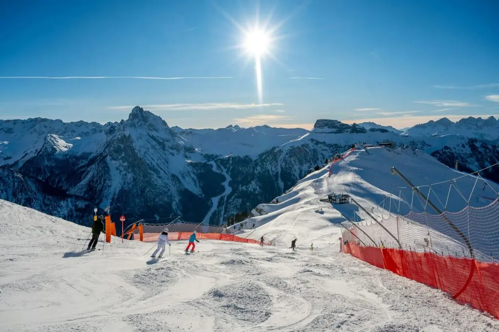 Skieurs en descente sur une piste balisée dans les Dolomites italiennes